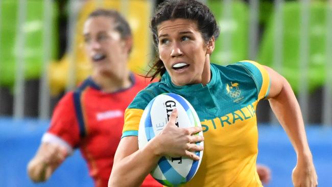 Australia's Charlotte Caslick runs with the ball in the women’s rugby sevens quarter-final match between Australia and Spain during the Rio 2016 Olympic Games at Deodoro Stadium in Rio de Janeiro on August 7, 2016. / AFP PHOTO / Pascal GUYOT