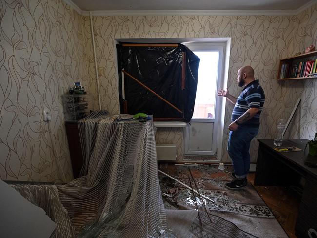 A man shows a broken window which was destroyed in his apartment by recent shelling in Kyiv. Picture: AFP