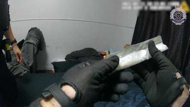 Police holding bag of white powder during alleged drug bust in Leo St, Mount Isa.