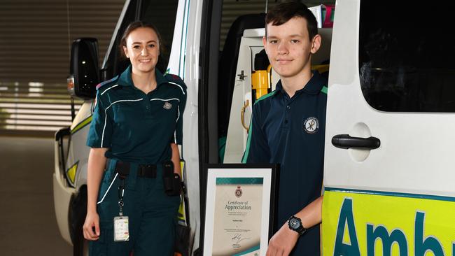 Hudson Hart, 13, has been honoured with an award from Queensland Ambulance Service for his bravery and maturity for calling triple-0 to help his mum who was suffering potentially life threatening Covid-19 symptoms. Pictured with Townsville paramedic, Emily Garn, who attended their home after the triple-0 call. Picture: Shae Beplate.