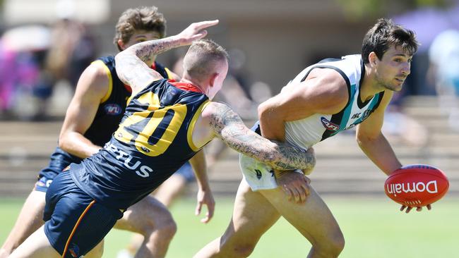 Sam Mayes seeks to handball as Ben Crocker looks to tackle during Saturday’s under-23 Showdown. Picture: AAP/David Mariuz