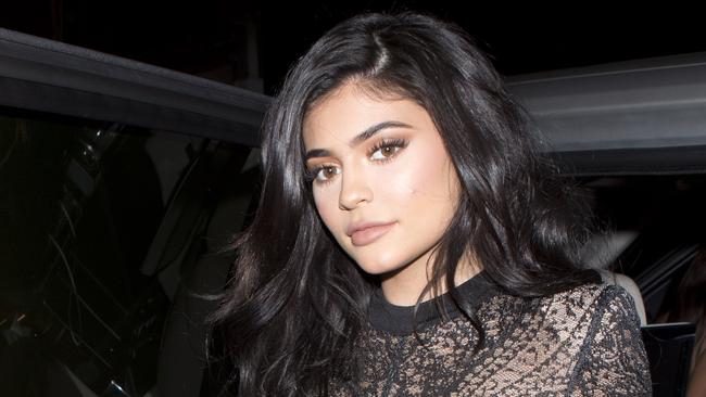 Kylie Jenner stuns in a sheer lace jumpsuit with a black duster