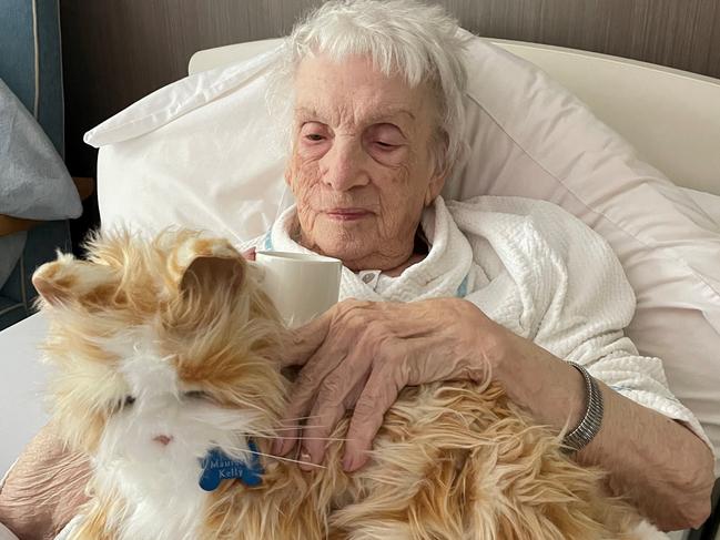 Carinity Cedarbrook aged care resident Maureen Kelly enjoys time with a therapeutic robotic companion pet, which provides physical and psychological benefits for seniors.