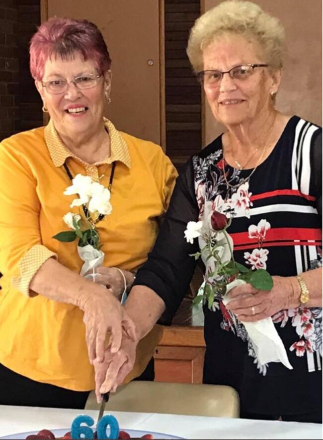 Patricia Keys Ballard (left) and fellow parishioner Fay Jordan share a cake to celebrate each of their 60-year marriages.