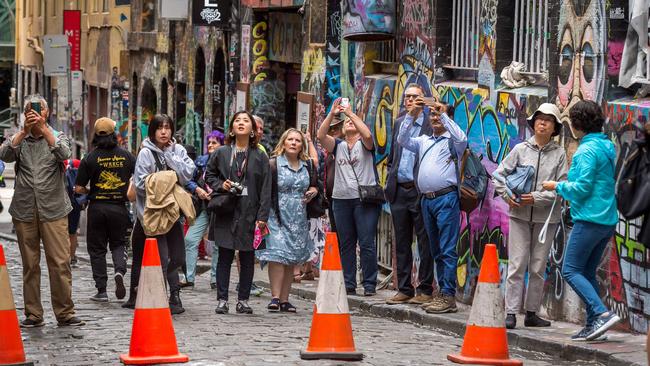 Tourists watch on and take pictures as crews clean up. Picture: Jake Nowakowski