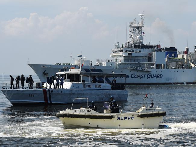 A Japanese Coast Guard ship PLH02 Tsugaru (background) and Philippine Coast Guard boat (centre) participate in a joint anti-piracy exercise in the waters off Manila Bay. Picture: AFP/Ted Aljibe