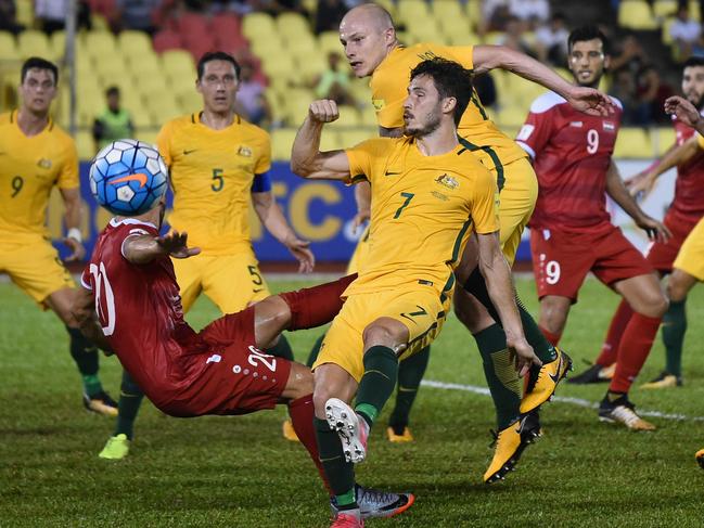 Khaled Almbayed of Syria (2L) and Mathew Leckie of Australia (C) fight for the ball during the 2018 World Cup qualifying football match between Syria and Australia at the Hang Jebat Stadium in Malacca on October 5, 2017. / AFP PHOTO / MOHD RASFAN