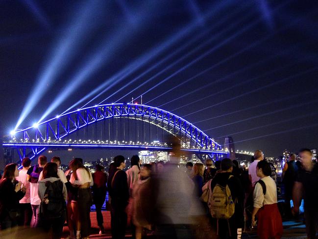 People look at a light projection onto the Sydney Harbour Bridge on the first night of Vivid Sydney 2019 in Sydney, Friday, May 24, 2019. Vivid Sydney runs from May 24 through to June 15 and is the largest festival of its kind in the southern hemisphere.  (AAP Image/Bianca De Marchi) NO ARCHIVING