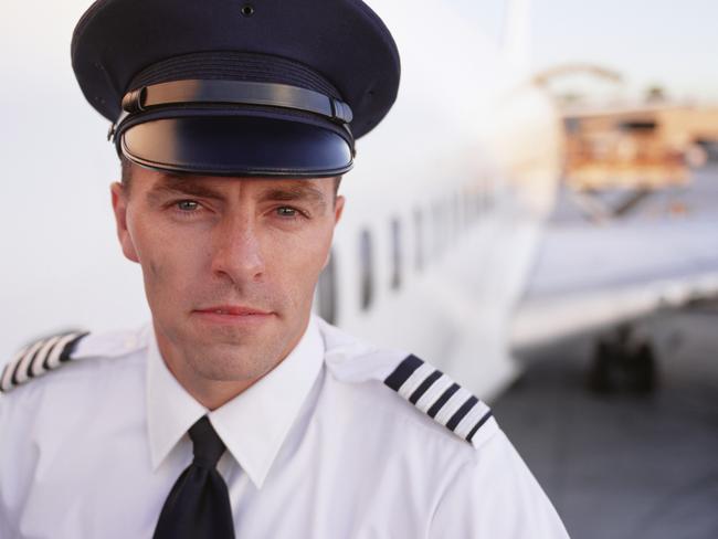 Pilot standing beside aeroplane at airport