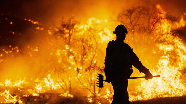 CASTAIC, CALIFORNIA - JANUARY 22: (EDITOR'S NOTE: Alternate crop) A firefighter works as the Hughes Fire burns on January 22, 2025 in Castaic, California. The wildfire has spread 9,400 acres and has prompted mandatory evacuations just over two weeks after the Eaton and Palisades Fires caused widespread destruction across Los Angeles County.   Brandon Bell/Getty Images/AFP (Photo by Brandon Bell / GETTY IMAGES NORTH AMERICA / Getty Images via AFP)