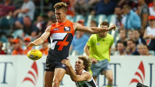 Adam Tomlinson gets his kick away in front of Chris Mayne. Pic: Getty Images