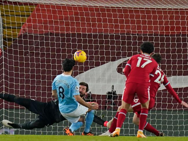 Manchester City's German midfielder Ilkay Gundogan shoots past Alisson Becker. (Photo by Tim Keeton/AFP)