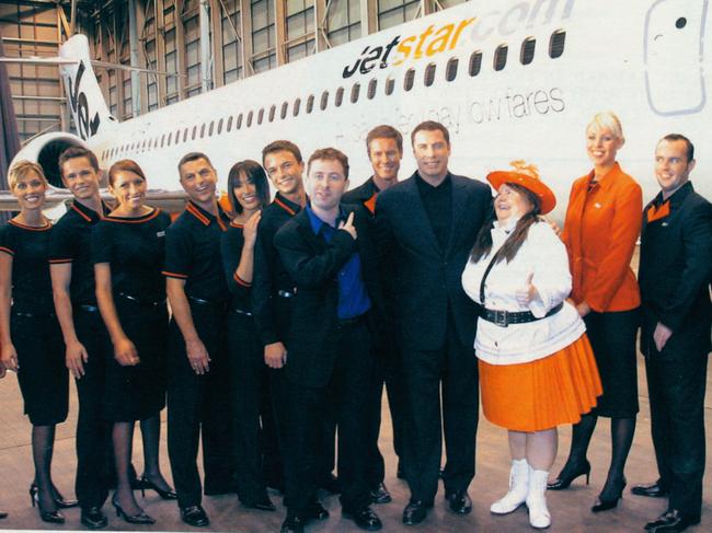 launch of Jetstar 15-years ago with then CEO Alan Joyce in the blue shirt with John Travolta and Magda Szubanski. Supplied by Jetstar. 08-08-19