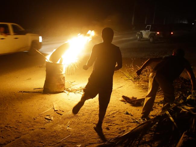 Youths light a bonfire while they protect their homes.