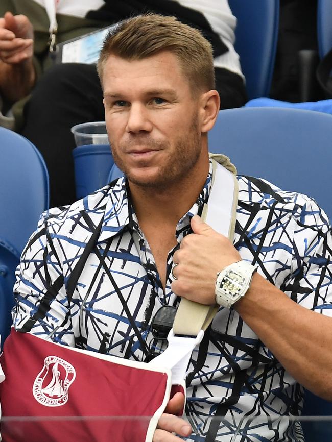 Australian cricketer David Warner is spotted at the Australian Open with his arm in a sling after recent elbow surgery. Picture: AAP