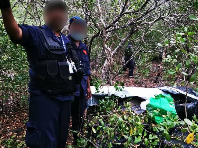 Police with the haul following the light plane crash. Picture: AFP