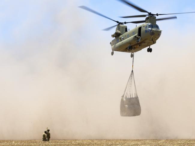 Australian Army CH-47 Chinooks from the 5th Aviation Regiment, load hay bales to deliver to remote bushfire affected farms on Kangaroo Island during Operation Bushfire Assist.