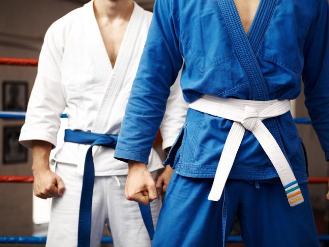 Two judo fighters stand their ground with fists ready to fight - cropped