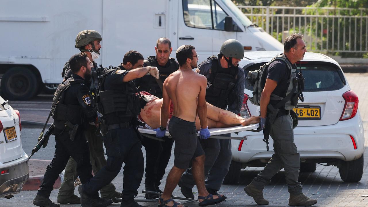 Members of Israeli security forces carry an injured person on a stretcher following a rocket attack from the Gaza Strip in Ashkelon. Picture: AFP