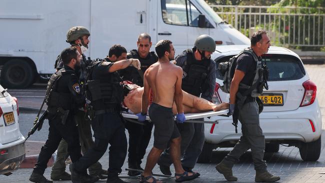 Members of Israeli security forces carry an injured person on a stretcher following a rocket attack from the Gaza Strip in Ashkelon. Picture: AFP