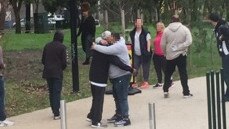 People hug outside the facility.