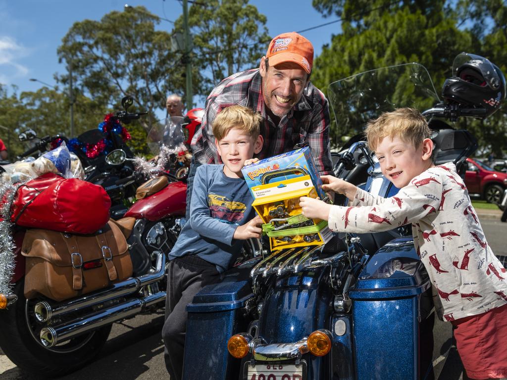 Cameron Voss gets a hand attaching the toys to his motorbike by his sons Victor (left) and Archie for the Toowoomba Toy Run hosted by Downs Motorcycle Sporting Club, Sunday, December 18, 2022.