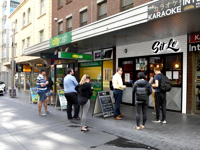 12.30pm. A few people mill around outside Vietnamese eatery Sit Lo on Bank St, which is only open for takeaway orders, in line with the new measures. Picture: Tricia Watkinson