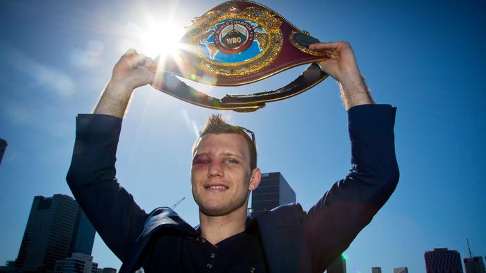 Newly crowned World Boxing Organization welterweight champion Jeff Horn of Australia poses for photographs with his belt during a press conference in Brisbane on July 3, 2017, one day after he beat the Philippines' Manny Pacquiao.  / AFP PHOTO / Patrick HAMILTON / IMAGE RESTRICTED TO EDITORIAL USE - STRICTLY NO COMMERCIAL USE