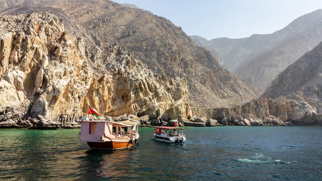 Tourist boats cruising Oman’s Musandam fjords.