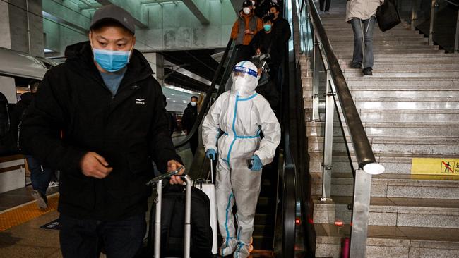 A passenger wearing protective gear is seen at a train station in Beijing overnight (AEDT). Picture: AFP