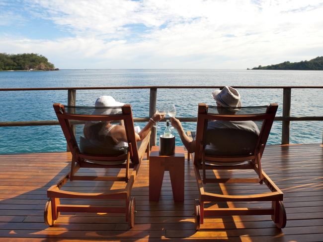 Couple relaxing on sun lounges in an over water bungalow, Fijicredit: iStockescape13 june 2021doc holiday