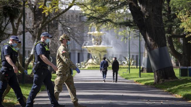 ADF members and police on patrol in the Carlton Gardens on Monday. Picture: Wayne Taylor