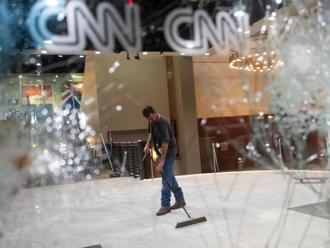 A worker cleans the lobby of CNN after rioting and protests in Atlanta after protesters descended on the studio. Picture: John Amis / Agence France-Presse / AFP