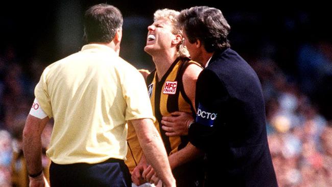 Dermott Brereton is assisted by club medics after being smashed by Mark Yeates at the first bounce of the 1989 grand final.