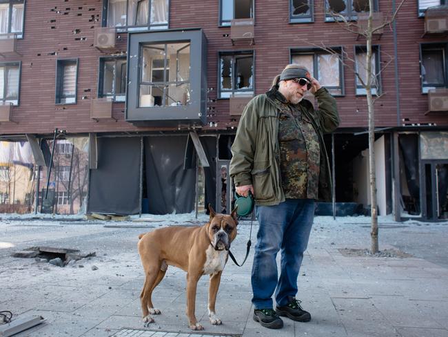 A man with a dog in front of a residential building hit by shelling in Kyiv. Picture: Getty Images