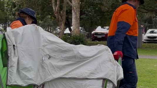 Gold Coast City Council workers remove abandoned tents from Carey Park at Southport.