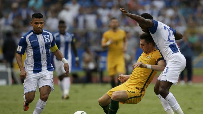 Australia's Tomi Juric, center, fights for the ball with Honduras' Johnny Palacios