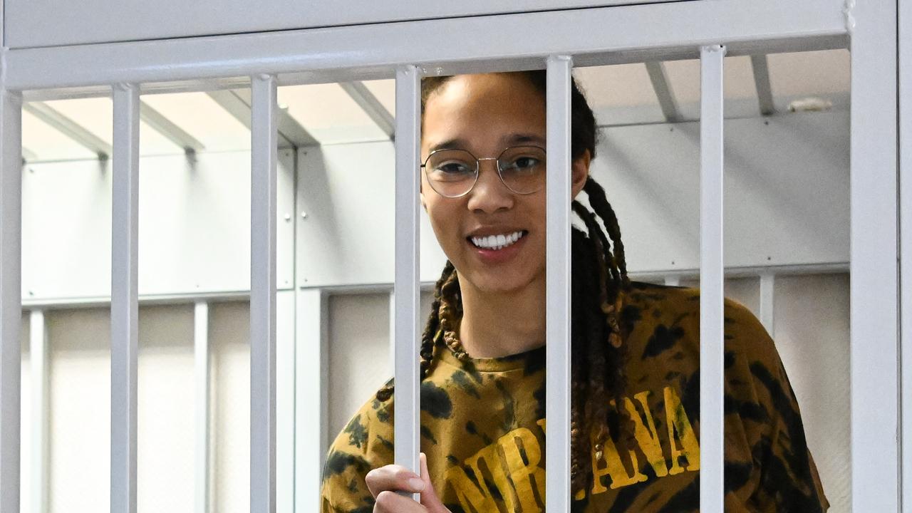 Brittney Griner smiles inside a defendants' cage during a hearing at the Khimki Court in the town of Khimki outside Moscow. (Photo by NATALIA KOLESNIKOVA / AFP)