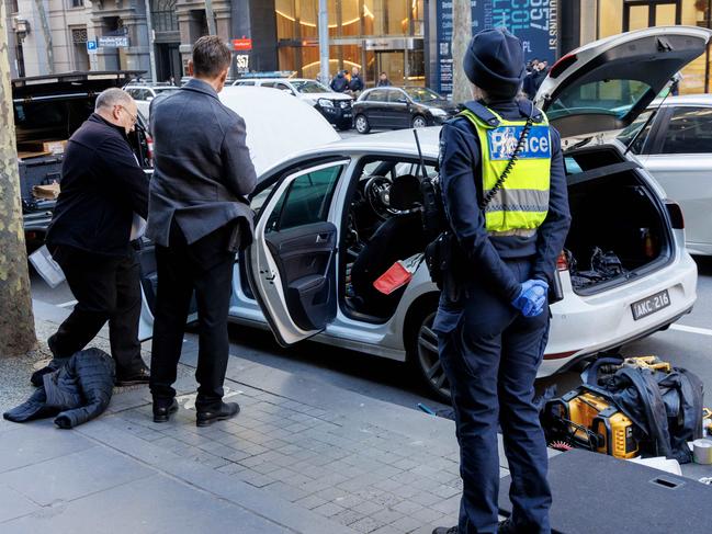 MELBOURNE, AUSTRALIA - NewsWire Photos - JUNE 19, 2024.  Police go through a white hatchback on Collins st after a major police incident with people reporting they were told to stay inside their office buildings.Picture: David Geraghty / NewsWire