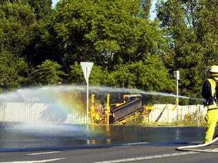 Firefighters hose down the ruptured gas main at the corner of Magellan and Diadem streets in Lismore last Thursday. . Picture: Cathy Adams