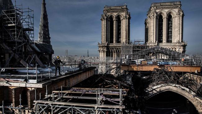 Workers on the roof of Notre-Dame remove the burnt scaffolding last year. Picture: AFP