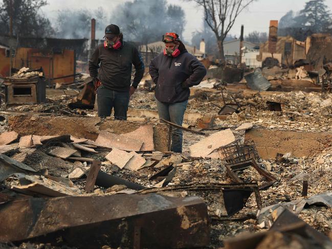 ALTADENA, CALIFORNIA - JANUARY 09: Khaled Fouad (L) and Mimi Laine (R) inspect a family member's property that was destroyed by Eaton Fire on January 09, 2025 in Altadena, California. Fueled by intense Santa Ana Winds, the Eaton Fire has grown to over 10,000 acres and has destroyed many homes and businesses.   Justin Sullivan/Getty Images/AFP (Photo by JUSTIN SULLIVAN / GETTY IMAGES NORTH AMERICA / Getty Images via AFP)