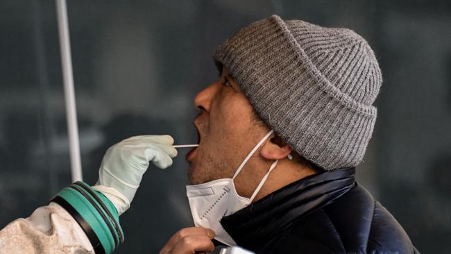 A health worker takes a swab sample from a man on December 26 as health experts predict 250 million Chinese are currently infected with Covid.