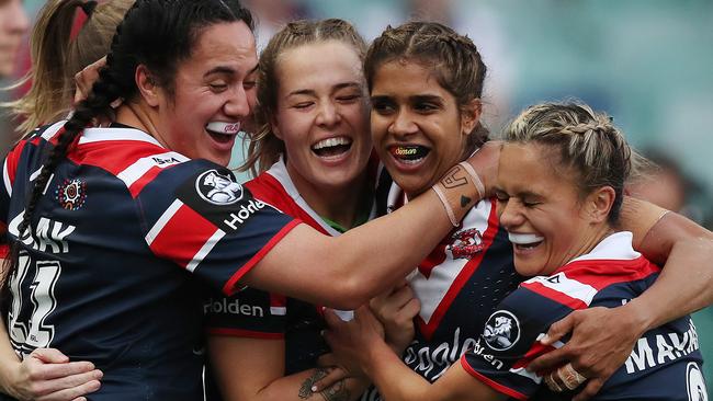 Roosters star Taleena Simon (second right) celebrates with teammates after she scored against the Dragons on Saturday. Picture: Brett Costello