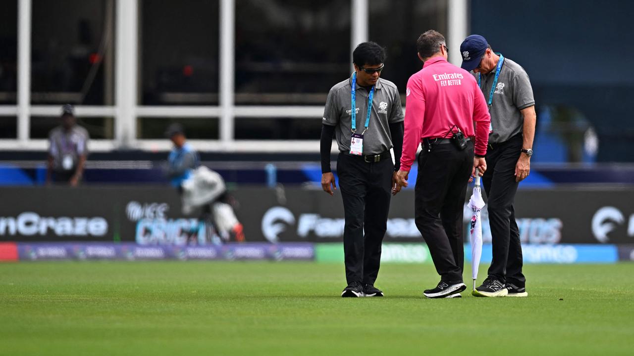 A huge downpour came after the umpires inspected the pitch to see if play could go ahead. (Photo by Chandan Khanna / AFP)