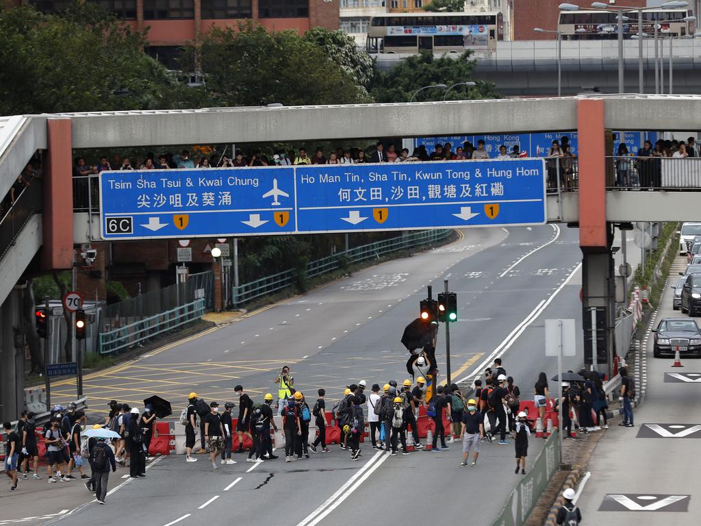 Protesters place barricades on a highway during a demonstration in Hong Kong. The protesters ignored police warnings and streamed past the designated endpoint for a rally Saturday. Picture: AP