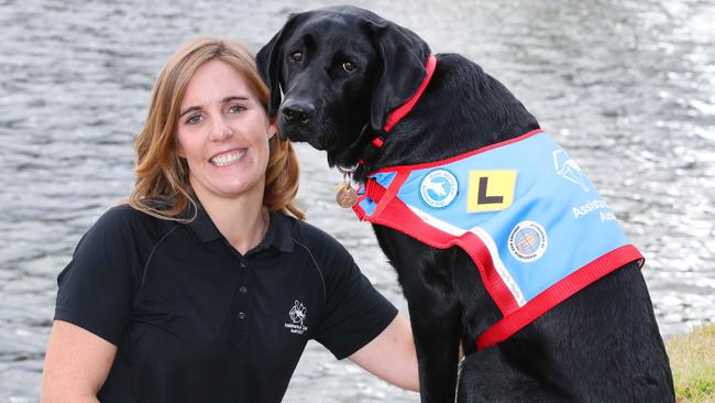 Carri Robinson with assistance dog Fergus, a 2 year old Labrador. Carri is the Gold Coast instructor for Assistance Dogs Australia and they are in desperate need of help. Picture Glenn Hampson