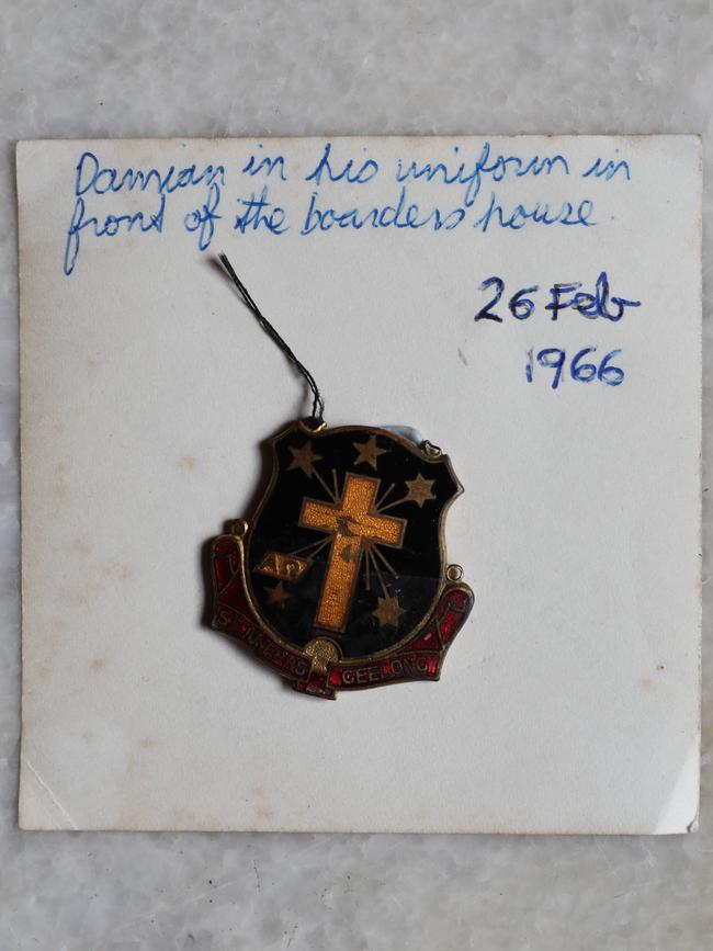 Damian’s old school badge taped to the back of a photograph.