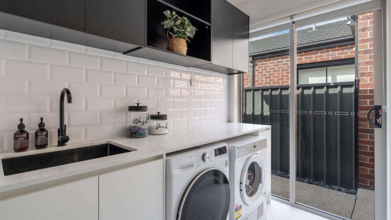 Even the laundry impressed buyers, with black tapware, overhead cabinetry and direct outdoor access making everyday tasks easier.