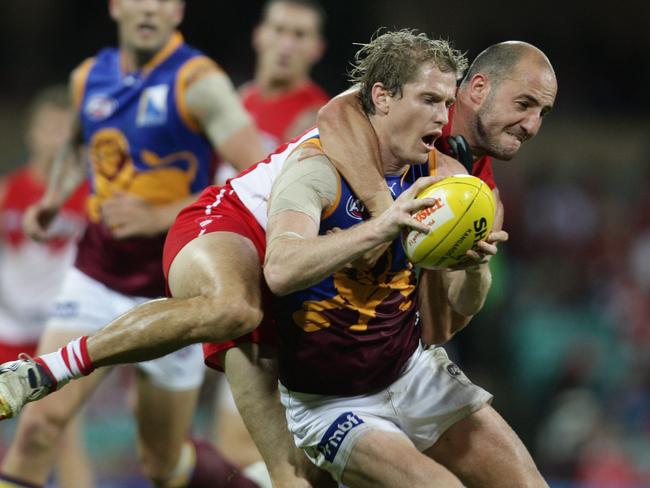 Tadhg Kennelly of the Swans tackles Troy Selwood of the Lions.